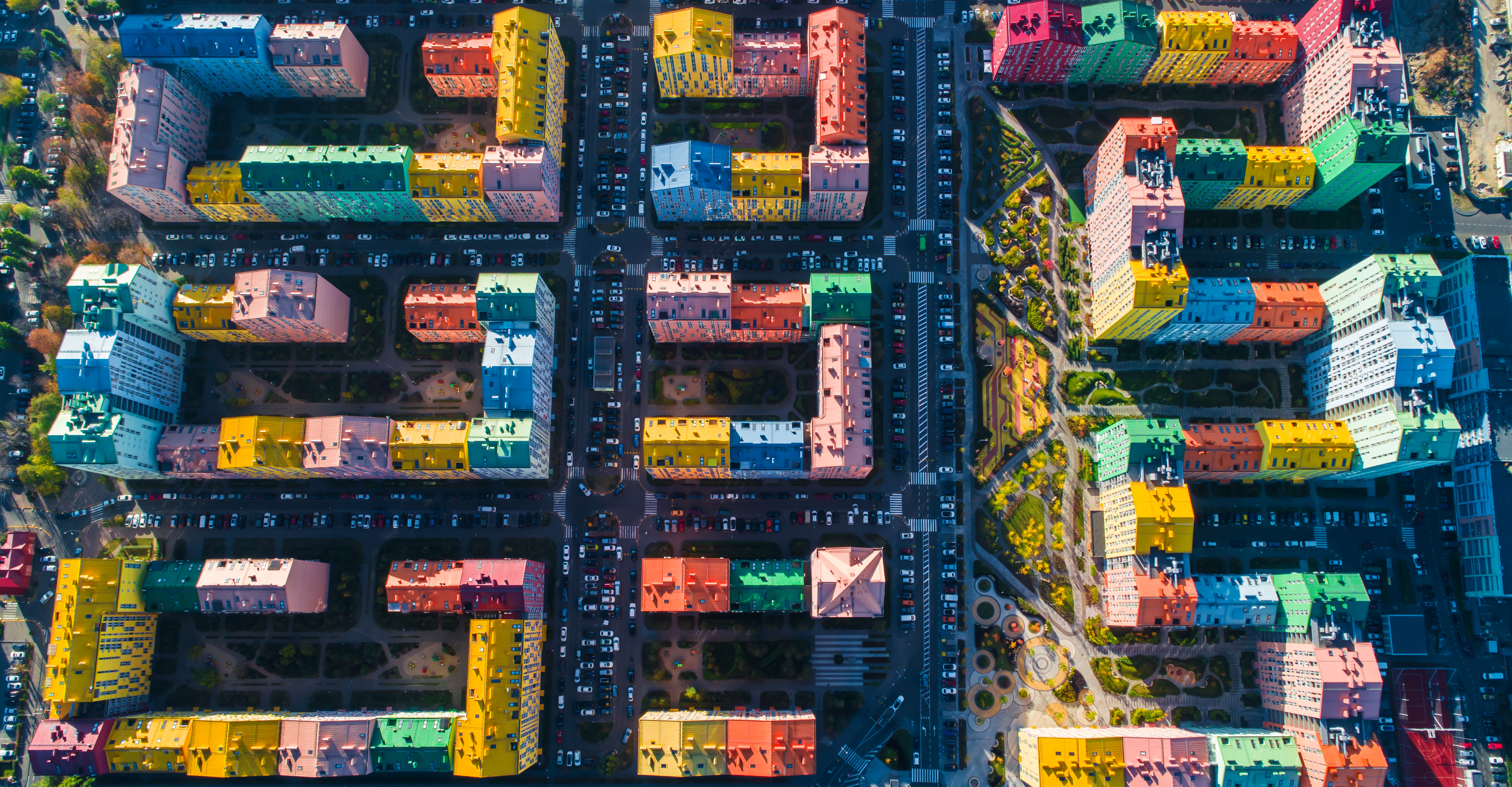 Aerial view of the colorful buildings in the European city in the morning sunlight. Cityscape with multicolored houses, cars on the street in Kiev, Ukraine.