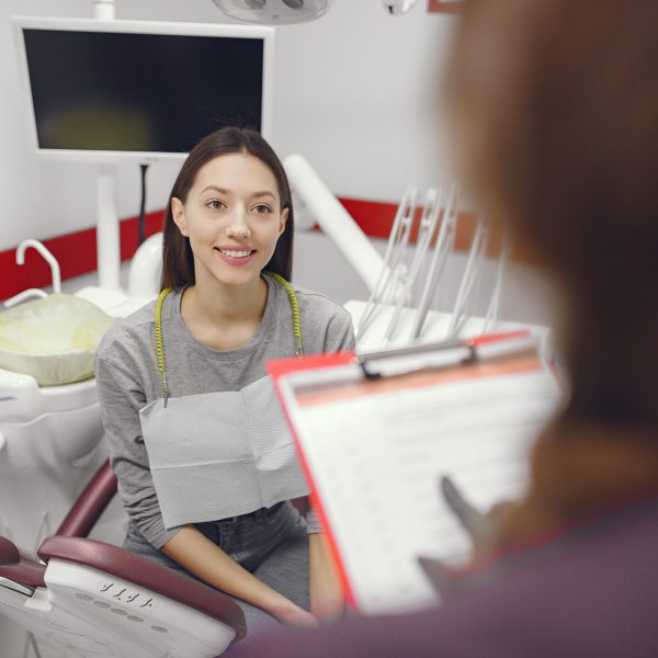 Beautiful lady in the dentist's office. Woman in a purple uniform