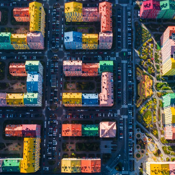 Aerial view of the colorful buildings in the European city in the morning sunlight. Cityscape with multicolored houses, cars on the street in Kiev, Ukraine.
